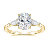 Bague 3 diamants en argent 925 couleur dorée avec une pierre principale ovale et deux pierres sur les côtés.