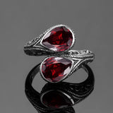 Bague argent 925 avec deux pierres rubis et des motifs creux sur l'anneau.