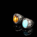 Deux bagues avec pierre naturelle, une avec un oeil de tigre ovale et une avec une turquoise ovale.