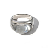 Bague cabochon en acier argenté avec une pierre ovale transparente.