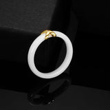 Bague céramique blanc pour femme avec un pendentif croix en acier doré.