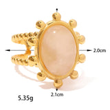 Bague femme pas cher dorée à double anneau avec une pierre rose ovale ornée de petites boules dorées.