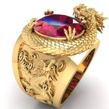 Bague couleur or homme, avec un dragon en relief protégeant une pierre rouge ovale, et des gravures de dragon sur les côtés.