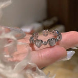 Bague ouverte à taille réglable en alliage de zinc avec de petits coeurs gris.