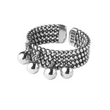 Bague pendentif en argent à motif de mailles, posée sur une surface blanche.