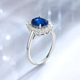 Bague saphir vue de profil avec une pierre centrale bleue et de petites pierres.