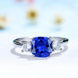 Bague tanzanite en argent massif avec tanzanite carrée artificielle bleue, posée sur une table.