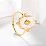 Bague femme torsadée en acier inoxydable doré, avec une pierre blanche et des bords dorés.