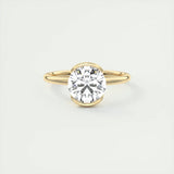 Bague solitaire dorée en argent 925 avec pierre centrale brillante posée sur la table.