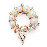 Magnifique broche représentant une couronne de fleurs. Cette broche est ornée de 7 belles perles et de petits strass fait en verre