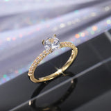 Alliance bague de fiançailles en laiton doré avec une pierre solitaire ronde et des zircons sur l'anneau.
