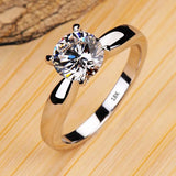 Bague en argent avec un poinçon 18K et un solitaire en zircone cubique ronde.
