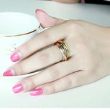 Bague 3 ors en acier inoxydable tricolore, portée élégamment sur le majeur d'une femme.