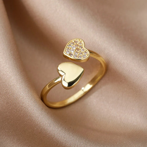Bague acier inoxydable femme, avec un anneau ouvert et deux cœurs, l'un lisse et l'autre pavé de petites pierres.
