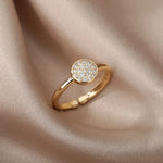 Bague acier inoxydable femme, avec un anneau fin et un cercle pavé de petites pierres.