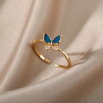 Bague acier inoxydable femme, avec un anneau fin et un papillon de couleur bleue.