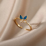 Bague acier inoxydable femme, avec un anneau fin et un papillon de couleur bleue.