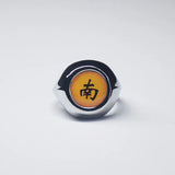 Bague Akatsuki avec l'anneau de couleur argent et une pierre jaune avec un kanji noir.