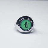 Bague Akatsuki avec l'anneau de couleur argent et une pierre verte avec un kanji noir.