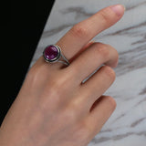 Bague améthyste vintage en argent portée au doigt d'une femme.