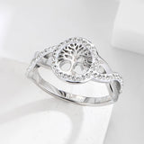 Bague arbre de vie argentée avec un médaillon ajouré et un anneau en spirale orné de cristaux.