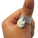 Bague avec médaille portée sur le pouce d'une femme.