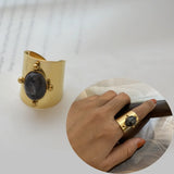 Bague bohème en acier inoxydable couleur dorée avec une pierre ovale noire.