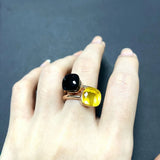 Bague bonbon en cuivre plaqué or rose avec une pierre noire et une pierre jaune.