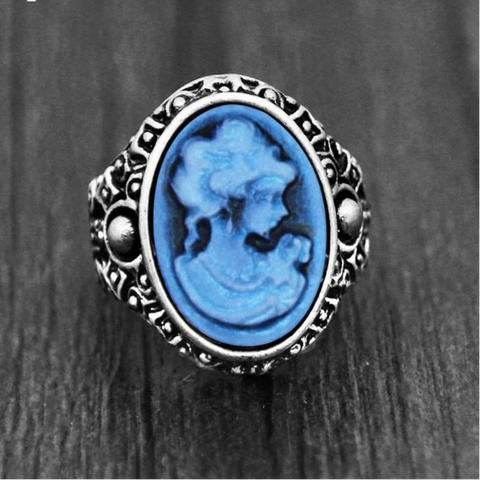 Bague camée couleur argent avec un visage de femme sculpté sur une pierre ovale bleue.