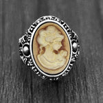 Bague camée avec un visage de femme sculpté sur une pierre ovale marron.