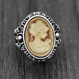 Bague camée avec un visage de femme sculpté sur une pierre ovale marron.