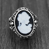 Bague camée avec un visage de femme blanc sculpté sur une pierre ovale noire.