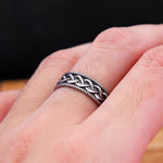 Main d'homme portant une bague celtique couleur argent sur le majeur.