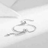 Bague chaînette argentée avec une chaîne fine et 2 pendentifs coeurs.