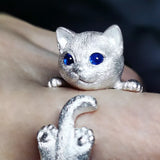 Gros plan sur la bague chaton en argent, yeux bleus, pattes et queue finement travaillées