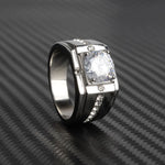 Bague chevalière homme argentée, avec un grand solitaire serti de griffes et un anneau orné de petites pierres.