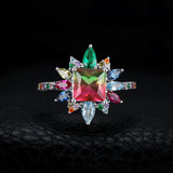 Bague cocktail vue de face sur fond noir, design floral multicolore éclatant