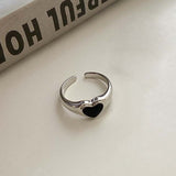 Bague cœur de couleur argent à taille réglable avec un cœur noir.