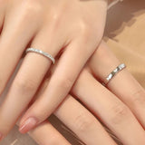 Deux bagues mariage femme en argent portées sur deux doigts de deux mains.