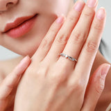 Une femme élégante portant une bague de fiançailles originale à motifs de vagues.