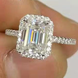 Gros plan sur une bague de mariage de luxe avec une grande pierre carrée entourée de petites pierres.
