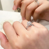 Bague de mariage diamant solitaire en argent plaqué platine portée sur l'annulaire d'une femme.