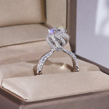 Bague de mariage diamant avec une pierre centrale entourée de zircones et un anneau en argent pavé de zircons.