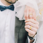 Deux mains, celles d'un couple, avec l'homme portant une bague mariage homme en titane, symbolisant l'union.