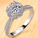 Bague de promesse en argent 925 avec une pierre centrale en zircone entourée de petites pierres brillantes.