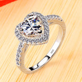 Bague de promesse en argent 925 avec une pierre centrale en forme de coeur sertie de petits diamants.
