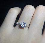 Bague de promesse en argent 925 scintillante portée sur l'annulaire d'une femme.