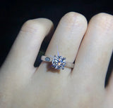 Bague de promesse en argent 925 scintillante portée sur l'annulaire d'une femme.