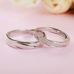 Bague de promesse couple en argent sterling, une pour homme et une pour femme, posées l'une au-dessus de l'autre.
