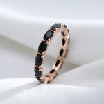 Bague diamant noir avec un anneau couleur rose gold serti de pierres ovales noires.